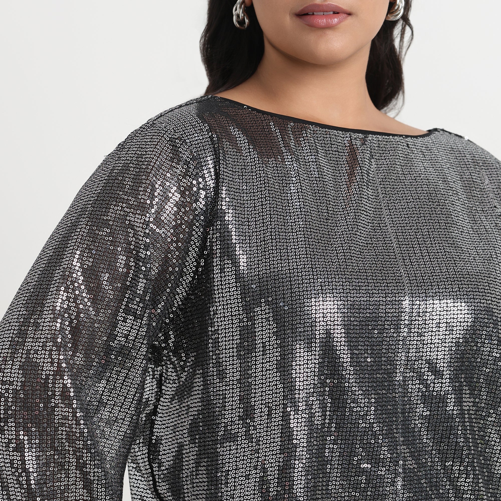 Silver sequin top with a shimmering finish, perfect for an elegant and festive look.
