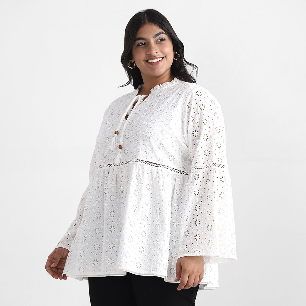 Image showcasing side profile of women in white schiffli top