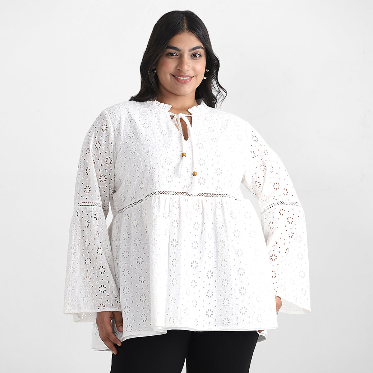 Image showcasing women in white schiffli top